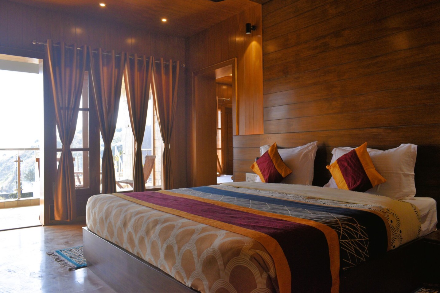 Luxury bedroom at Shivalaya Resort by Botanix featuring wooden interiors, elegant lighting, and cozy bedding for a serene mountain retreat.