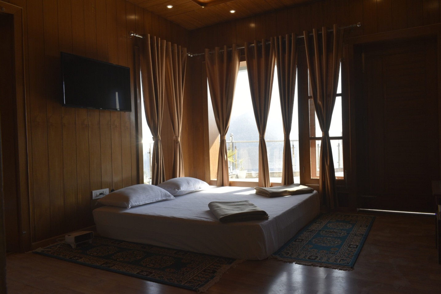 Luxury bedroom at Shivalaya Resort by Botanix featuring wooden interiors, elegant lighting, and cozy bedding for a serene mountain retreat.
