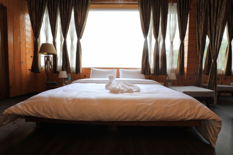 Luxury bedroom at Shivalaya Resort by Botanix featuring wooden interiors, elegant lighting, and cozy bedding for a serene mountain retreat.