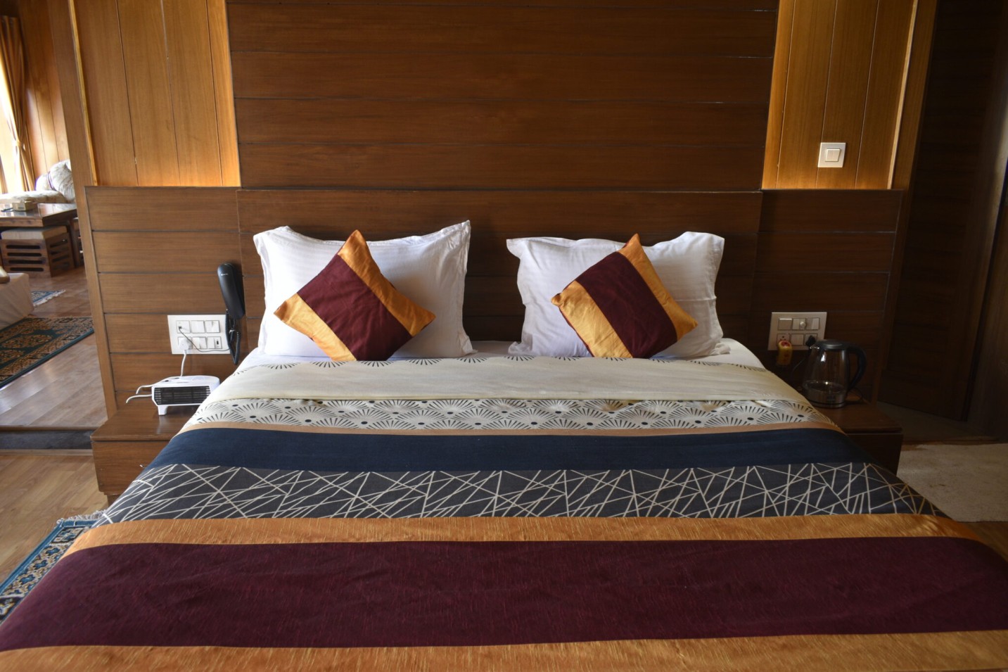 Luxury bedroom at Shivalaya Resort by Botanix featuring wooden interiors, elegant lighting, and cozy bedding for a serene mountain retreat.